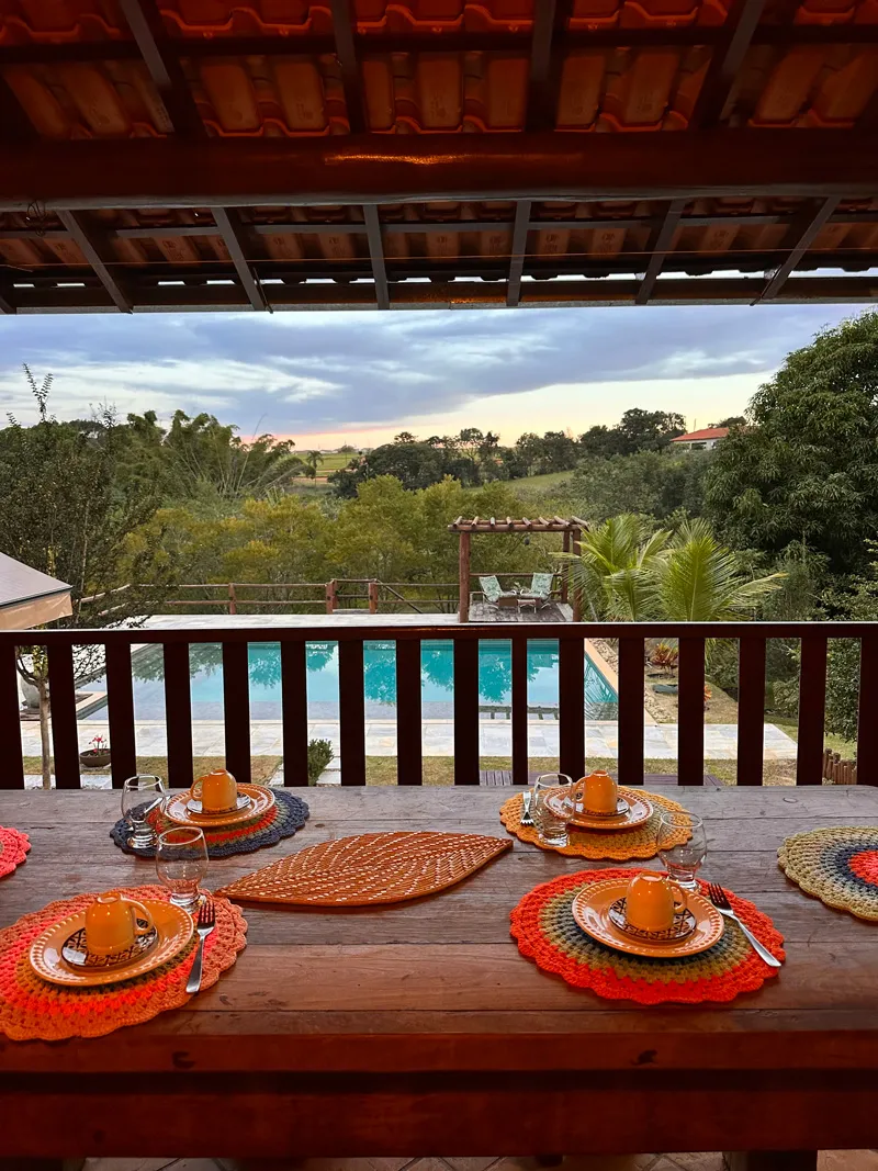 Mesa de café na varanda com vista para a piscina e a natureza